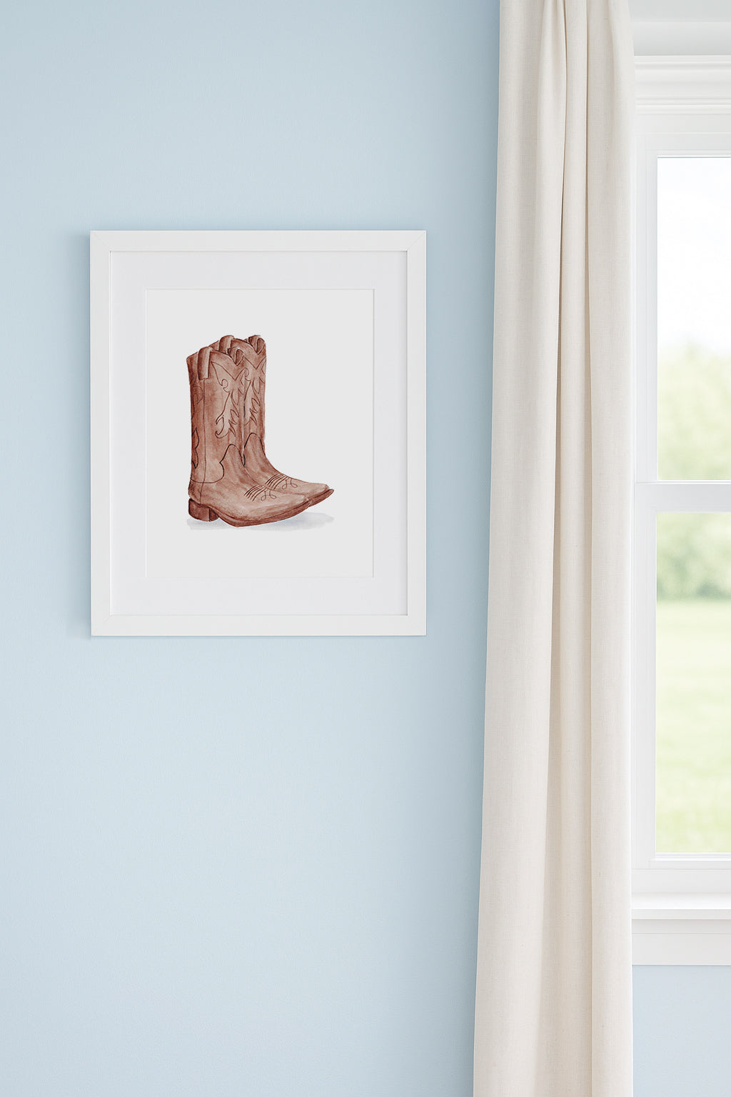 Framed artwork of a cowboy boot on a light blue wall.