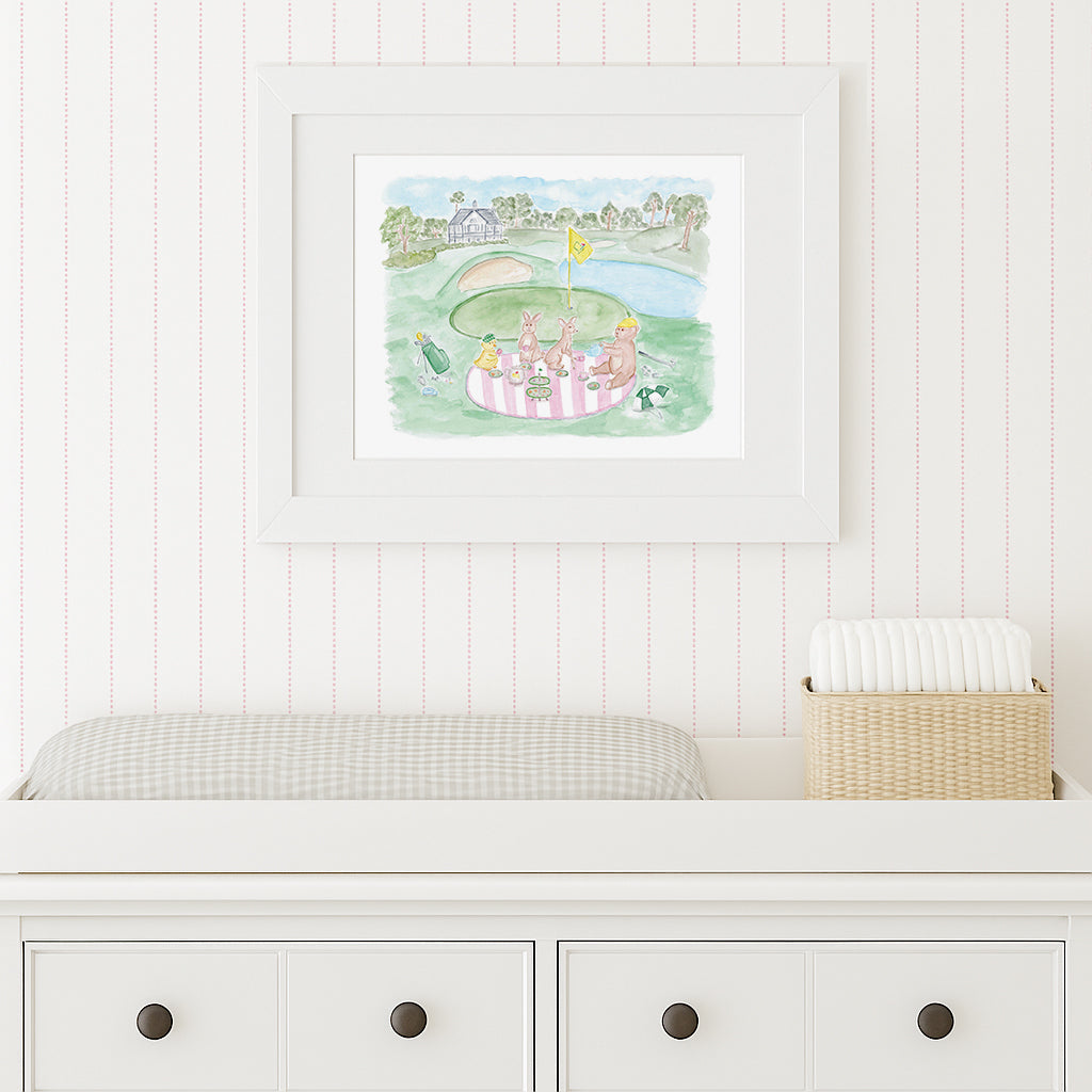 Framed artwork of a garden scene with people on a white wall above a white dresser.